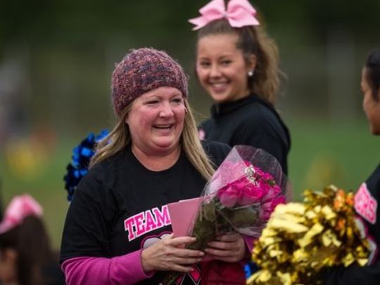 Colleen receives flowers on her birthday prior to the start of a Spotswood High School football game on Saturday Oct. 3, 2015
